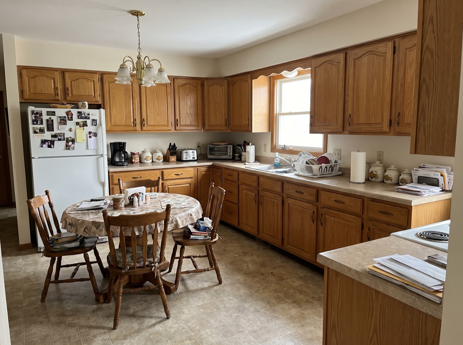 Lived-in kitchen with crowded counters and a cluttered dining table